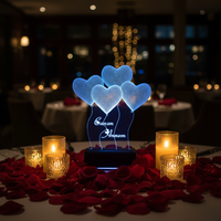 Heart shaped 3D illusion LED lamp in romantic setting with rose petals and candles